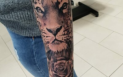 Ein Tiger Tattoo auf dem ganzen Unterarm einer Frau 