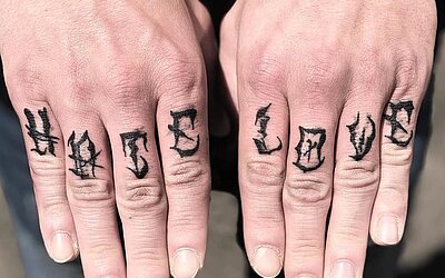 Lettering Tattoo mit Hate und Love auf den Fingern 
