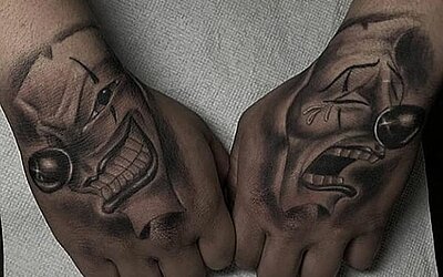 Handtattoo, zwei Masken, eine weint, eine lacht