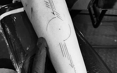 geometric shapes finely tattooed on the forearm