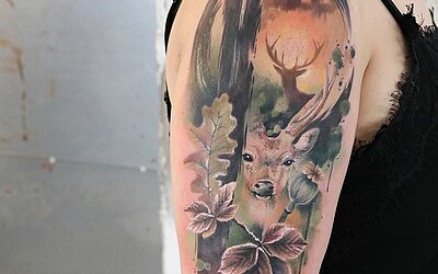 Oberarm Watercolor Tattoo mit einem Hirsch in herbstlichen Farben