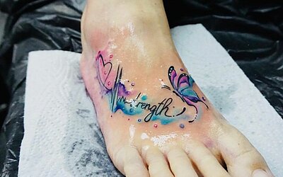 kleines Watercolor Tattoo mit Schriftzug auf dem Fuß