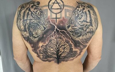 Zwei Tiger und ein Baum mit Blitzeinschlag auf dem Rücken eines Mannes