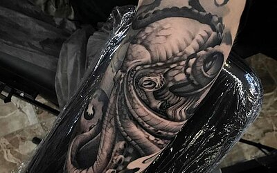 Tatuaje realista negro y gris de pulpo