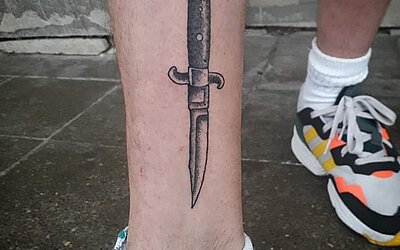 Switchblade tattooed on his shin