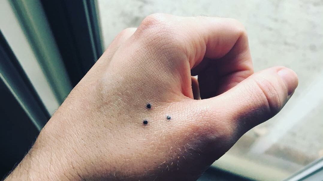 three dots tattoo arranged in a triangle, on the hand. 