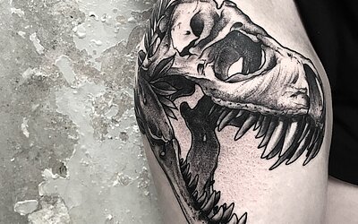 Ein großes Totenkopf Tattoo auf dem Oberschenkel einer Frau